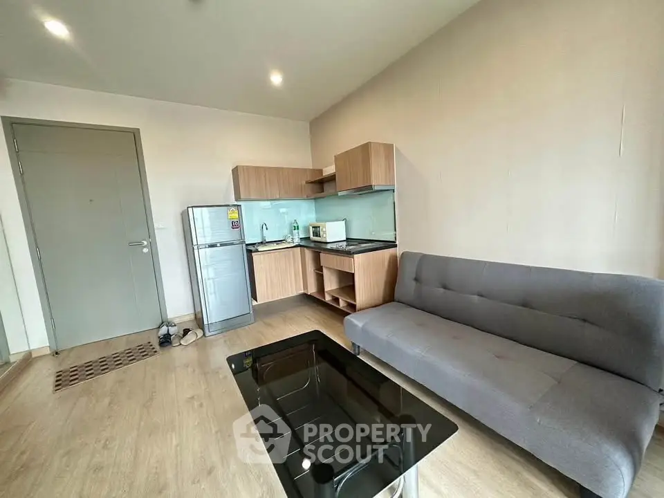 Modern apartment living room with compact kitchen and sleek furnishings