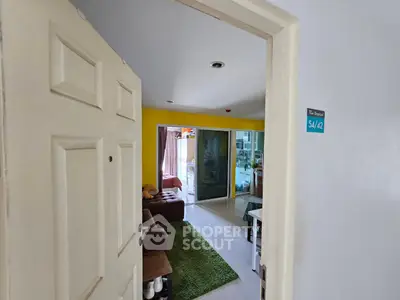Inviting living room with vibrant yellow accent wall and cozy seating area