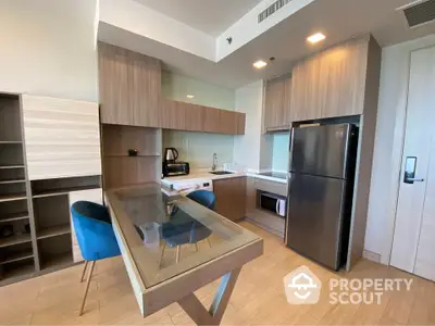 Modern kitchen with sleek cabinetry and glass dining table in stylish apartment