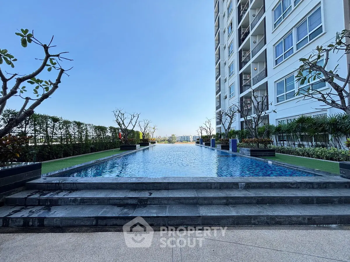 Luxurious high-rise building with stunning pool and lush greenery, offering a serene urban oasis.