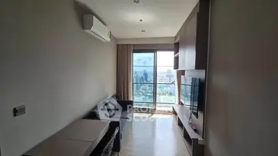 Modern living room with city view, featuring sleek furniture and large window for natural light.