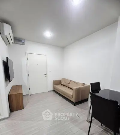 Modern living room with sleek furniture and minimalist design, featuring a comfortable sofa and wall-mounted TV.