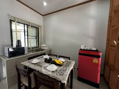 Cozy dining area with modern appliances and elegant table setting in a compact kitchen space.