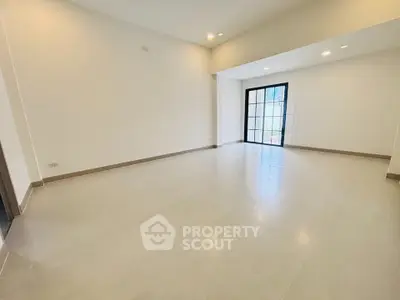 Spacious empty living room with large windows and bright natural light