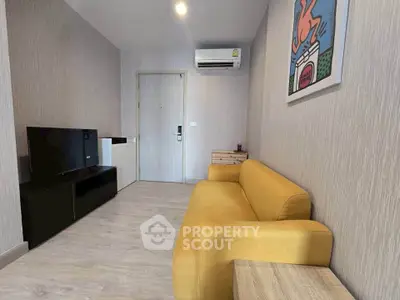 Modern living room with yellow sofa and wall art, featuring sleek TV setup and air conditioning.