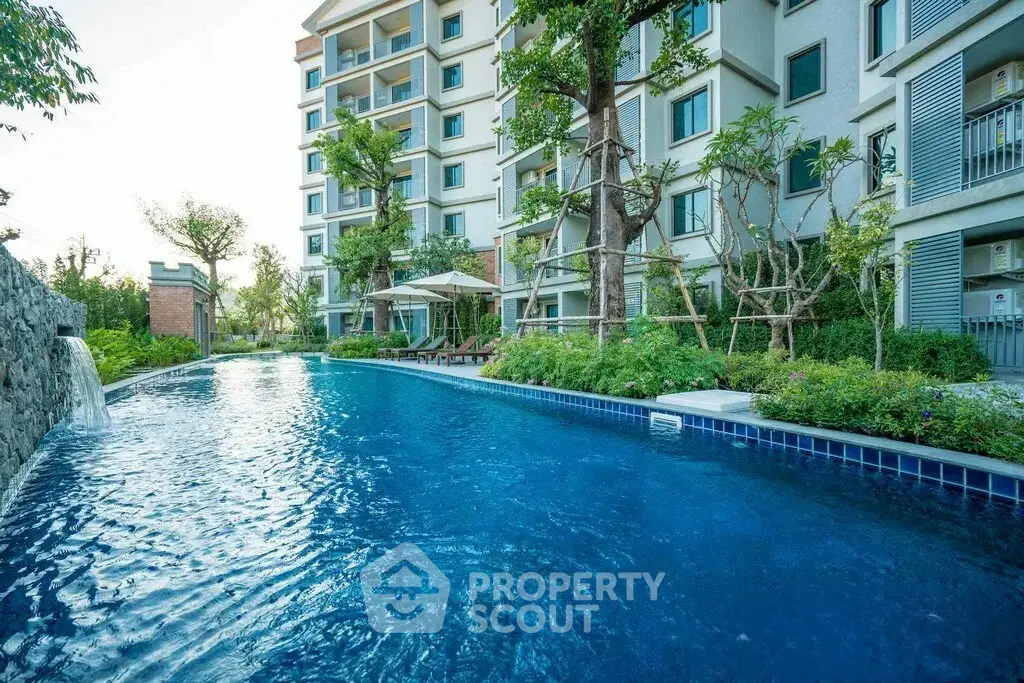 Luxurious apartment building with stunning pool and lush greenery, perfect for modern living.