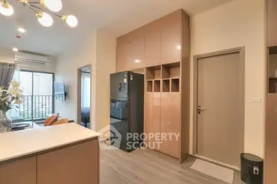Modern apartment interior with sleek kitchen and open layout, featuring stylish cabinetry and bright lighting.