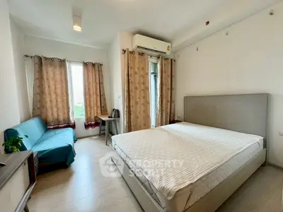 Spacious bedroom with modern decor and natural light, featuring a comfortable bed and stylish curtains.