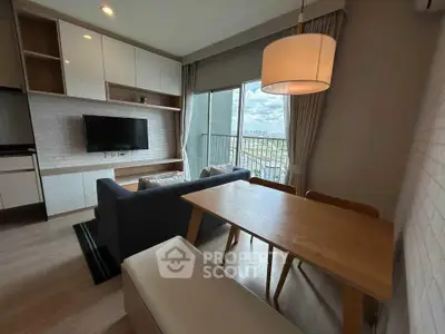 Modern living room with stylish furniture and large window offering a stunning city view.