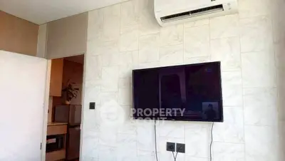 Modern living room with wall-mounted TV and air conditioning unit, featuring sleek design and neutral tones.