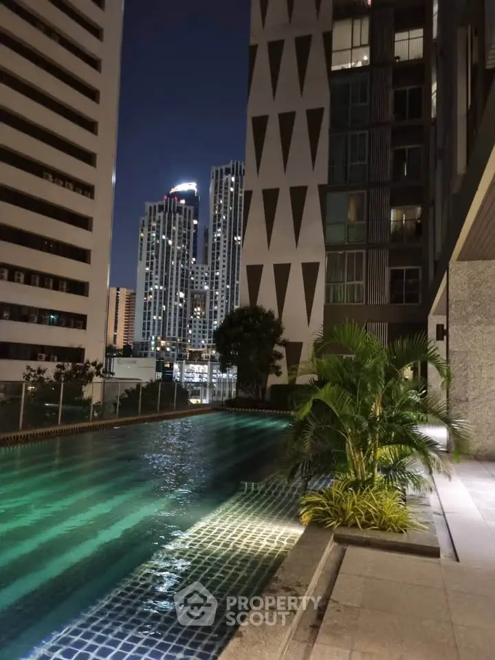 Luxurious high-rise apartment with stunning night pool view and city skyline.