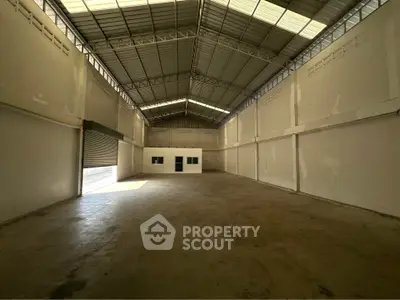 Spacious industrial warehouse with high ceilings and ample natural light.