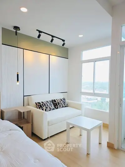 Modern living room with white sofa and large windows offering natural light