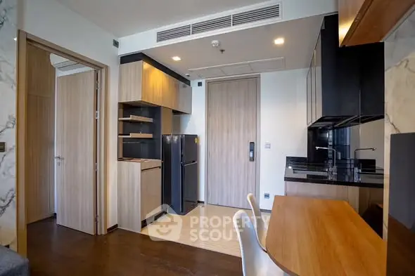 Modern apartment interior with sleek kitchen and dining area, featuring wooden accents and contemporary design.