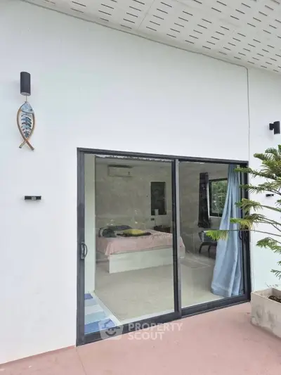 Modern bedroom with large glass sliding doors and outdoor view