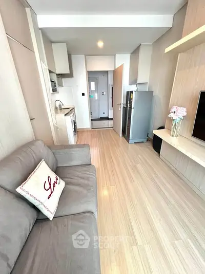 Modern living room with sleek kitchen, cozy sofa, and stylish decor in a contemporary apartment.