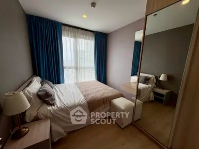Cozy bedroom with large window and modern furnishings, perfect for relaxation and comfort.