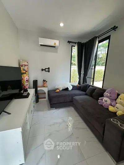 Cozy living room with plush sofa and large windows offering natural light.