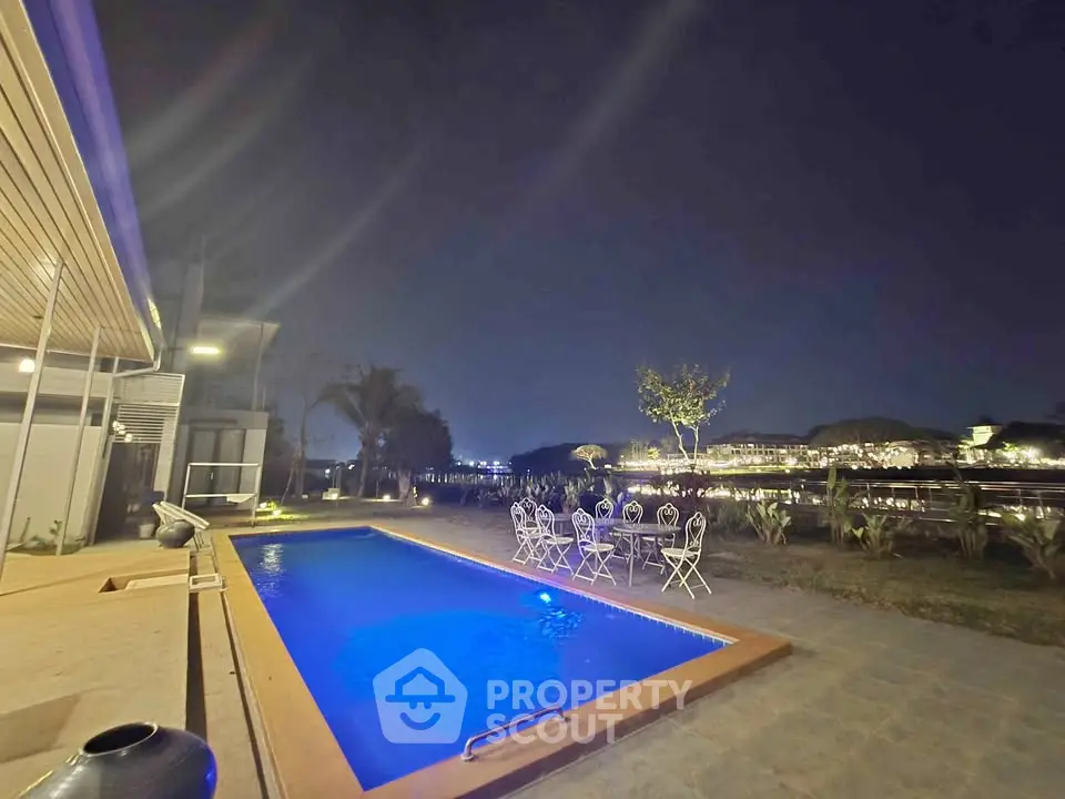 Luxurious night view of a private pool with elegant outdoor seating, perfect for relaxation and entertainment.