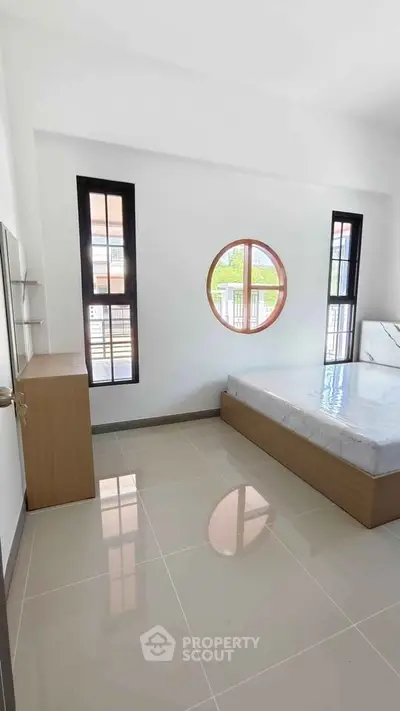 Modern bedroom with unique circular window and minimalist design