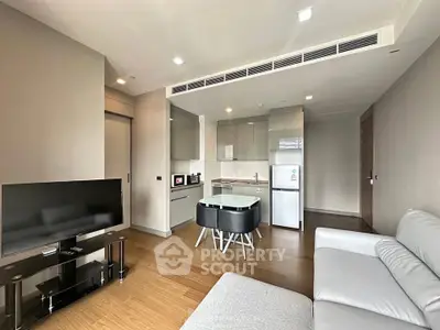 Modern living room with open kitchen and sleek furniture in a stylish apartment.