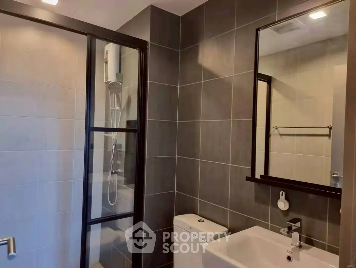 Modern bathroom with sleek shower and stylish fixtures in contemporary apartment.