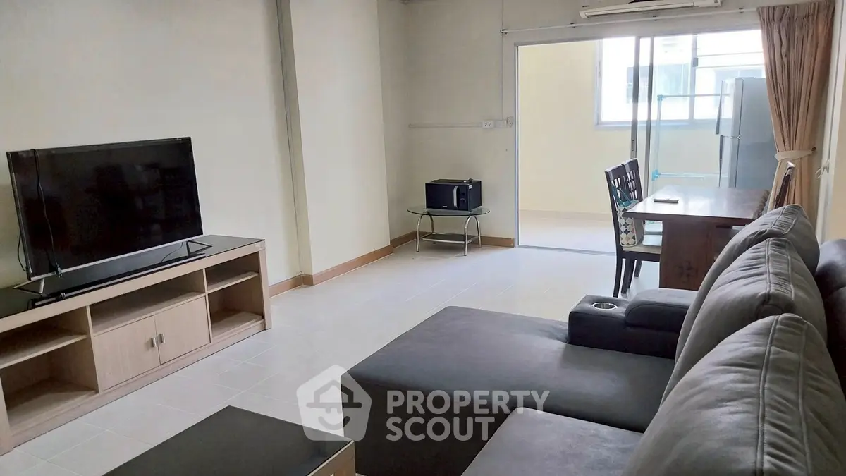 Spacious living room with modern furniture and natural light, perfect for relaxation and entertainment.