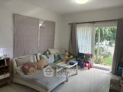 Cozy living room with modern furniture and garden view, perfect for relaxation and family gatherings.