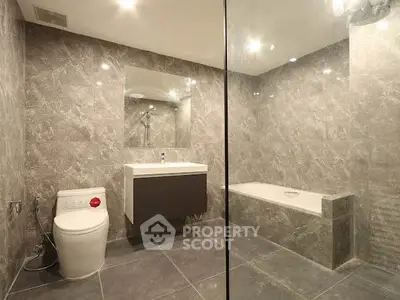 Luxurious modern bathroom with elegant marble tiles and sleek fixtures.