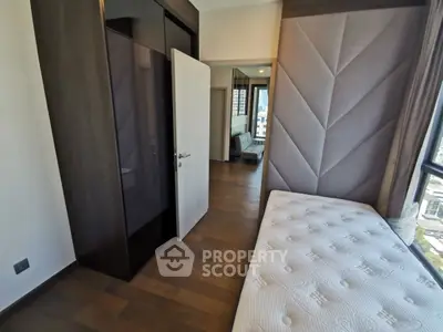 Modern bedroom with stylish design and large window offering natural light and city view.
