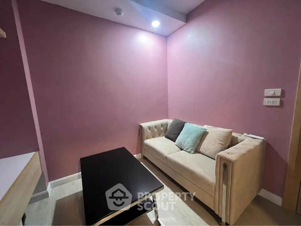 Cozy living room with pink walls and modern sofa, perfect for relaxation.