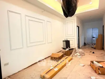 Spacious interior under renovation with elegant wall paneling and recessed lighting.