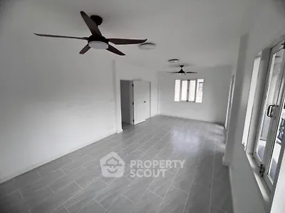 Spacious unfurnished room with modern ceiling fans and large windows for natural light.