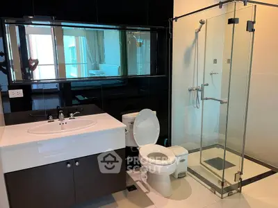 Modern bathroom with glass shower and sleek vanity in luxury apartment