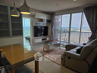 Spacious living room with modern decor and stunning balcony view in high-rise apartment.