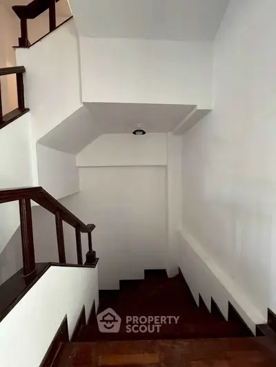 Elegant staircase with dark wood accents in a modern home interior.