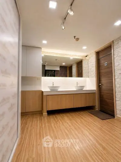 Modern bathroom with dual sinks and wooden flooring in a stylish apartment.