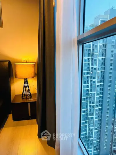 Modern bedroom with city view and stylish lamp by the window