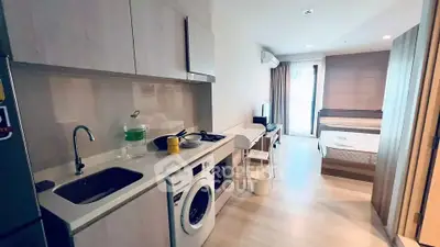 Modern studio apartment with integrated kitchen and cozy bedroom area, featuring sleek appliances and stylish decor.