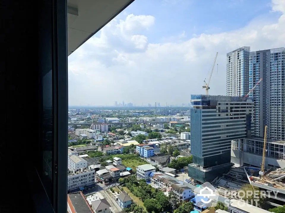 Stunning cityscape view from high-rise building with construction crane and modern architecture.