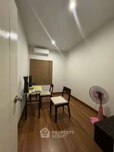 Cozy study room with wooden flooring, modern furniture, and air conditioning.