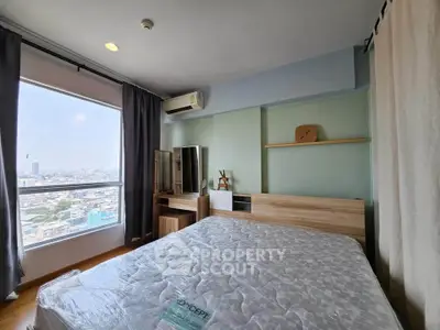 Modern bedroom with city view, featuring stylish furniture and large window for natural light.