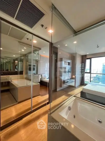 Luxurious modern bedroom with glass-enclosed bathtub and city view