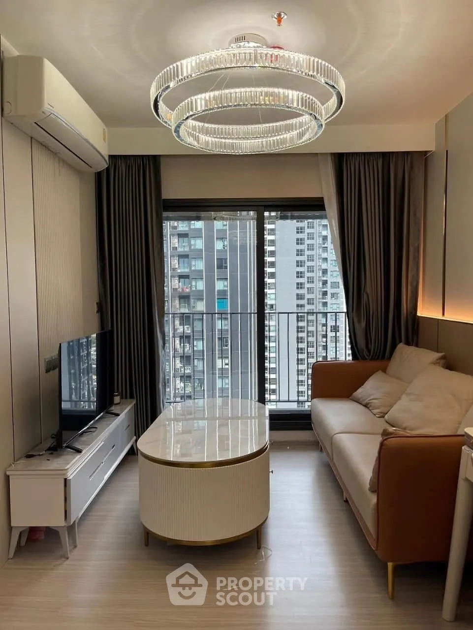 Modern living room with elegant chandelier and city view