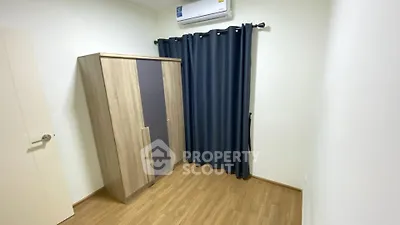 Compact bedroom with wooden wardrobe and air conditioning unit