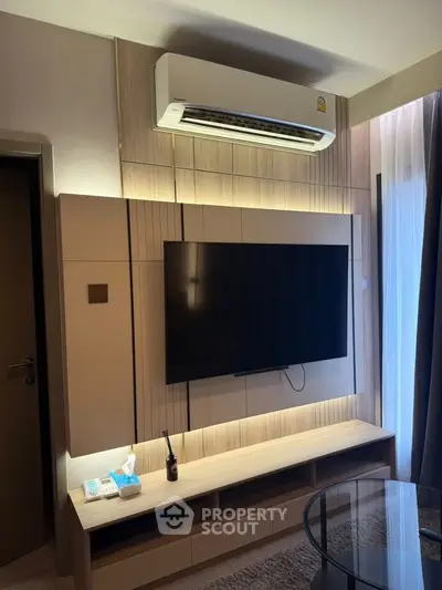 Modern living room with sleek TV setup and air conditioning, perfect for comfortable living.
