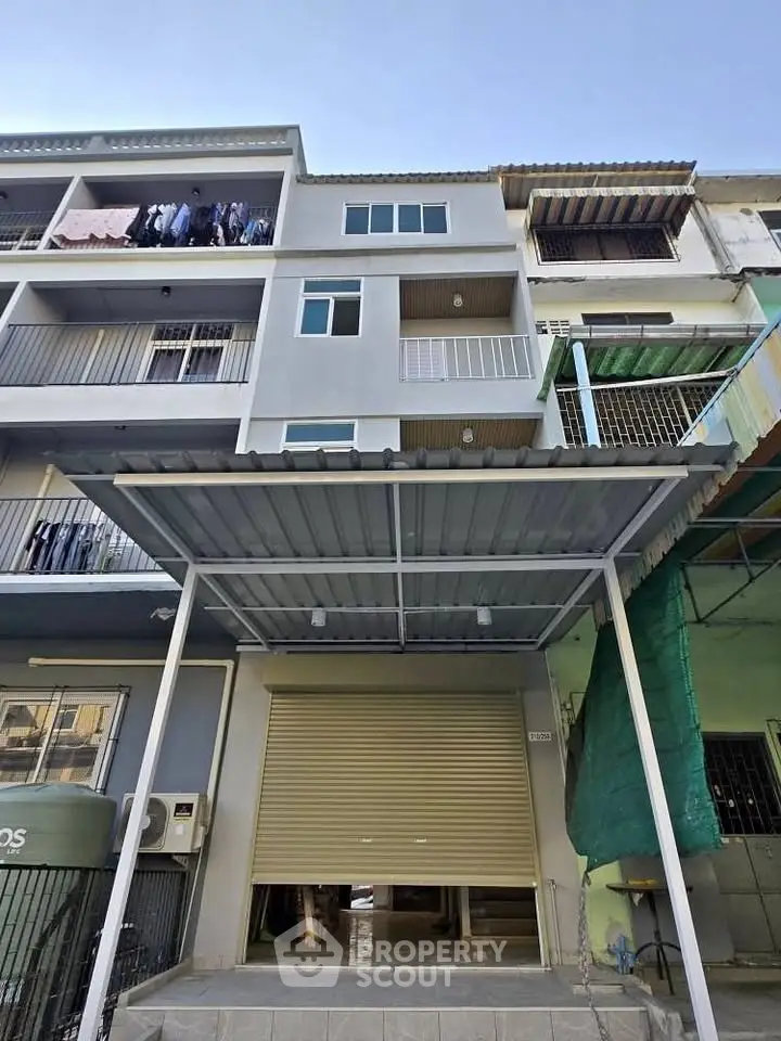 Modern multi-story building with balconies and garage entrance, ideal for urban living.