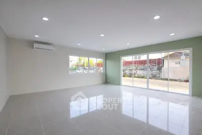 Spacious modern living room with large windows and sleek tile flooring