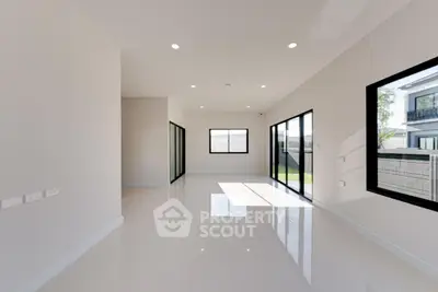 Spacious modern living room with large windows and glossy floors