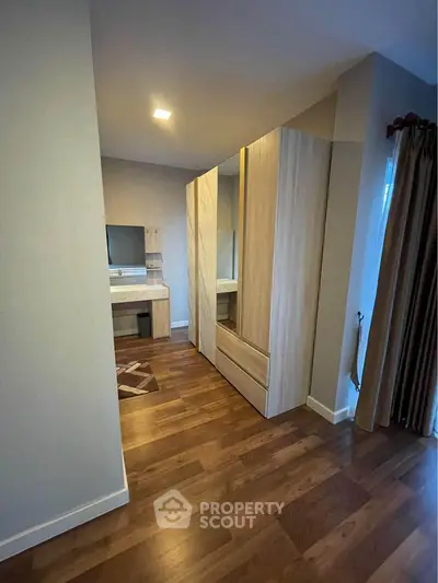 Spacious bedroom with elegant wooden flooring and modern wardrobe design